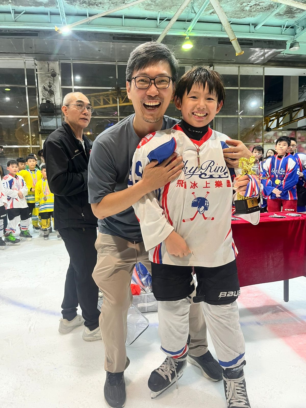Coach and player celebrating together after the medal presentation