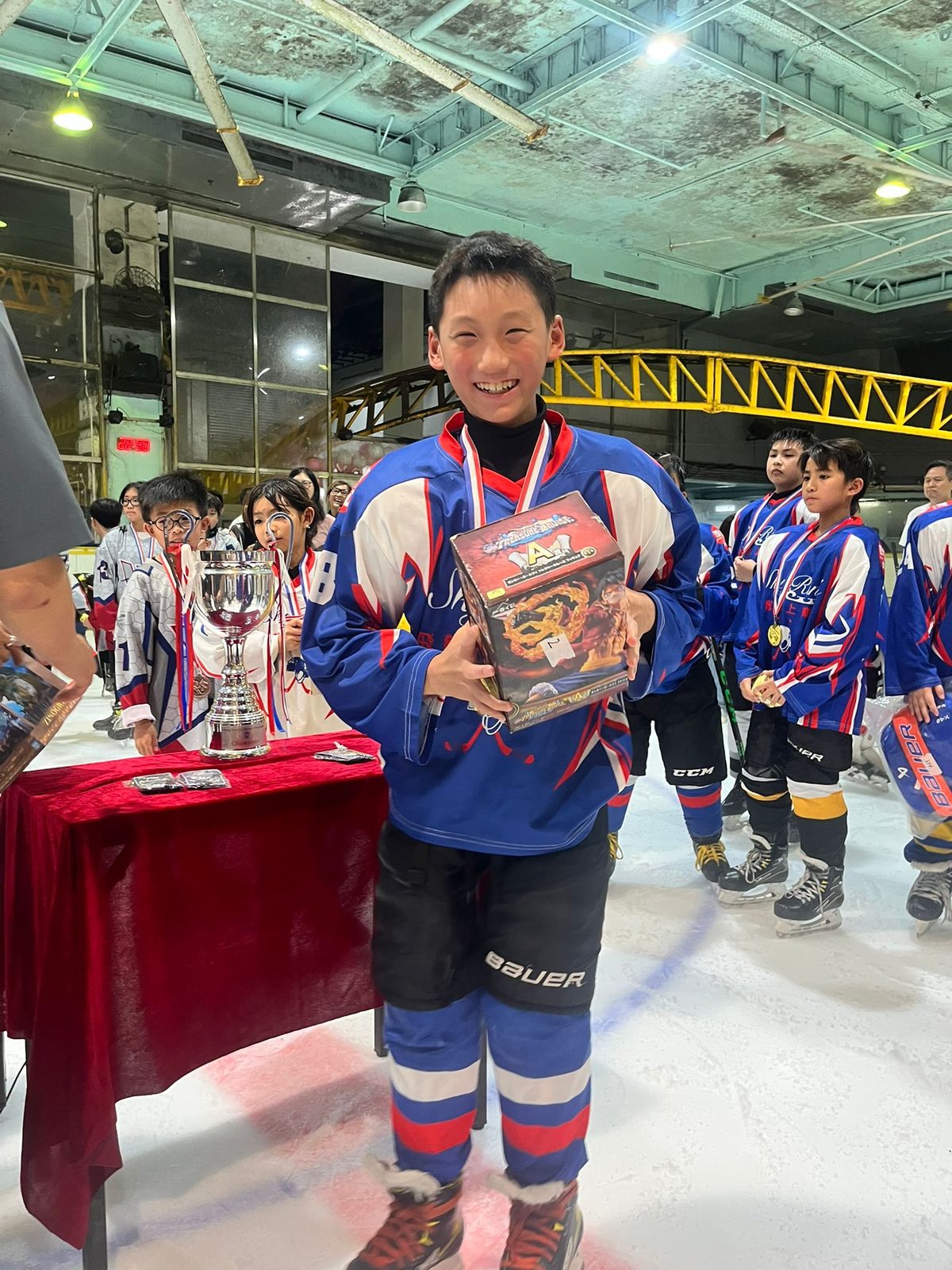 Player with his medal and prize beside the tournament cup