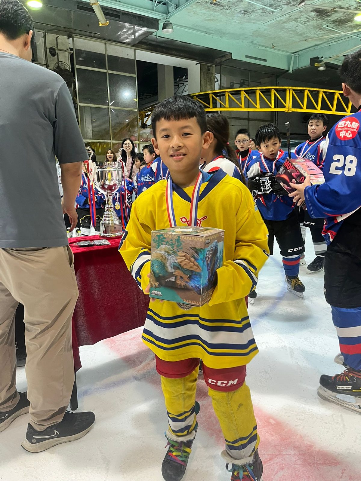 Player in a yellow jersey with his medal and prize